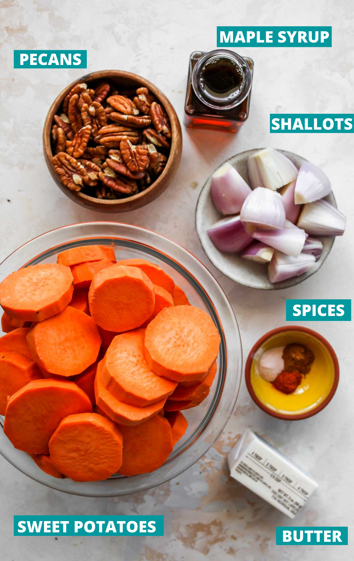 Sweet potatoes, pecans, shallots, and spices in separate bowls with blue labels