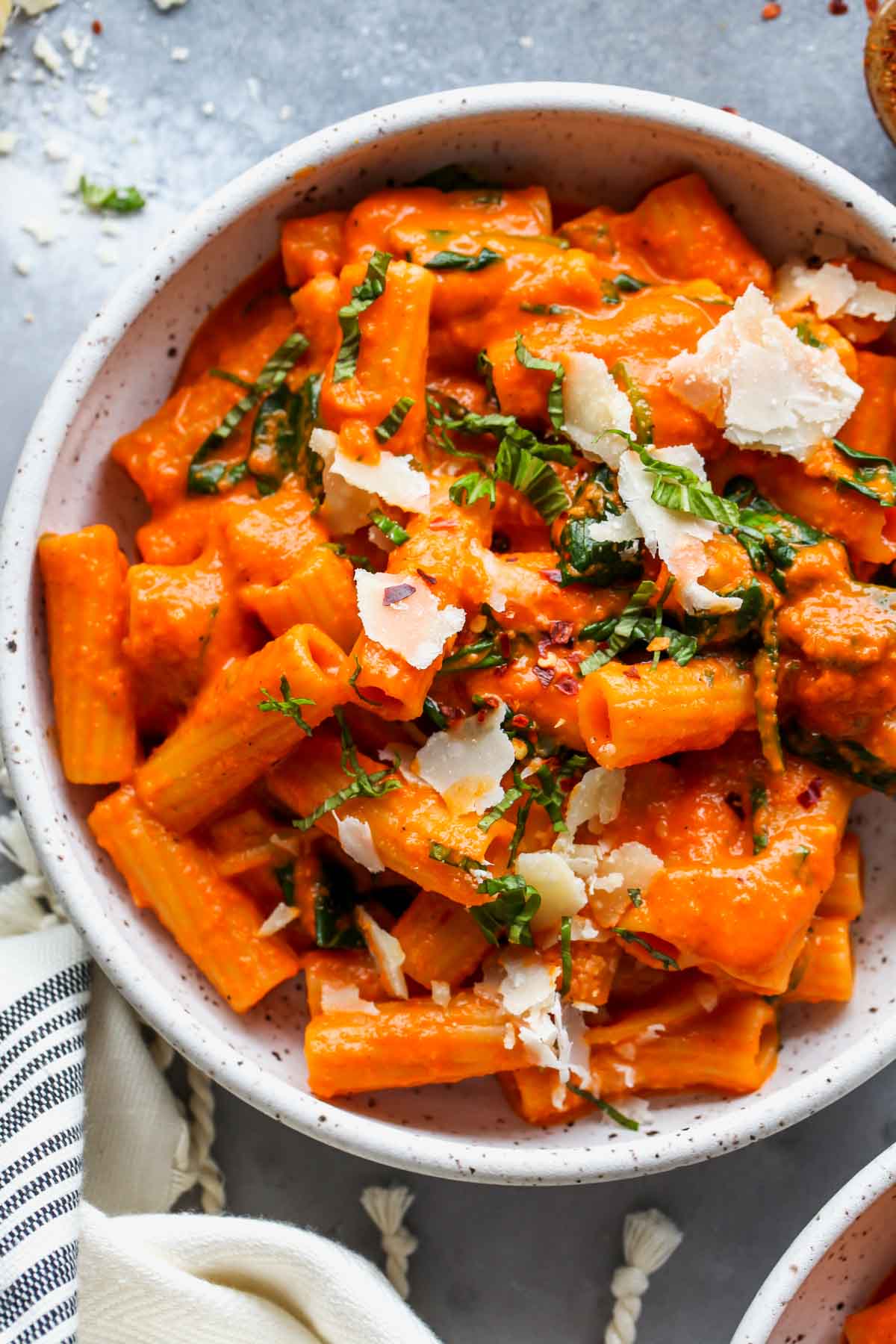 Creamy Red Pepper Pasta in a white bowl topped with basil