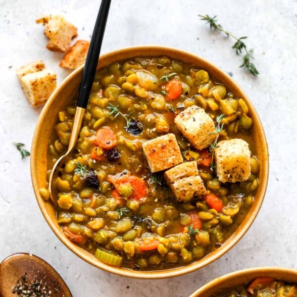 Split pea soup served in a gold bowl with a black spoon
