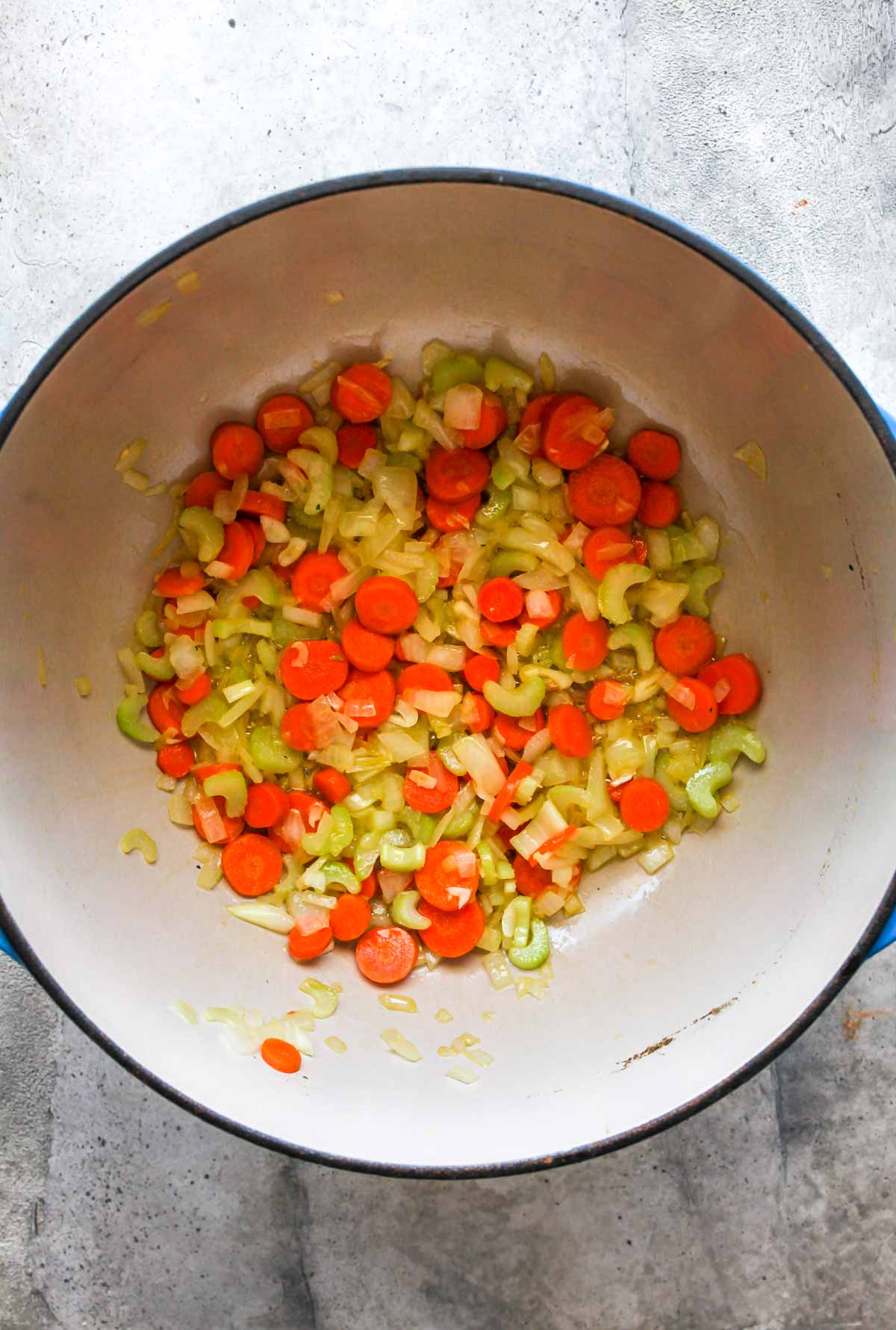Onion, carrots, and celery sauting in olive oil in a Dutch oven