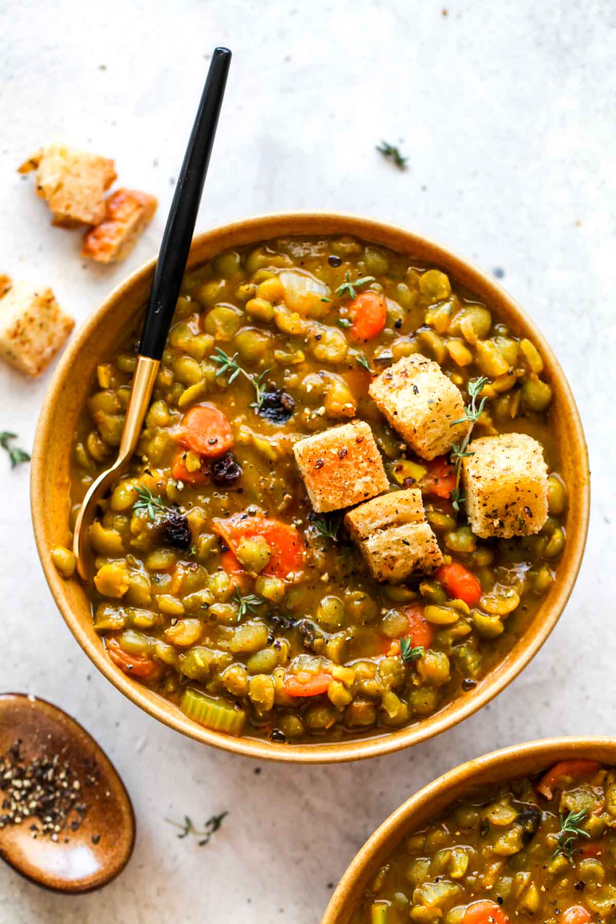 Gold bowl filled with split pea soup topped with croutons