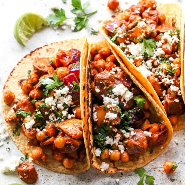 Al Pastor Chickpea Tacos topped with herbs, onion, and cheese