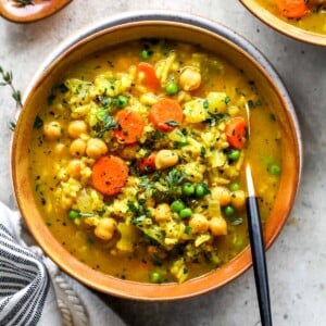 Bowl of chickpea and rice soup topped with fresh thyme