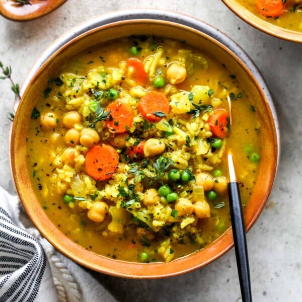 Bowl of chickpea and rice soup topped with fresh thyme