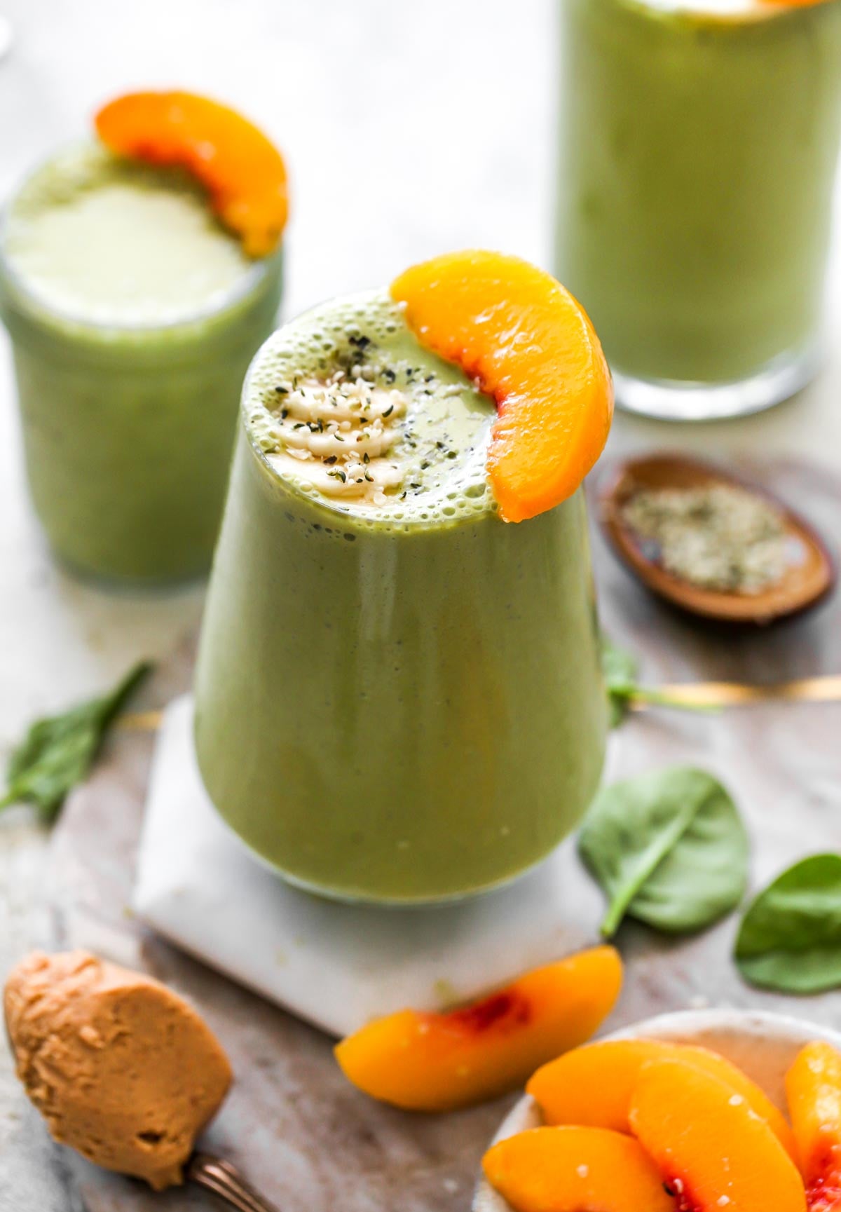 Banana Peach Green Smoothie topped with a peach slice
