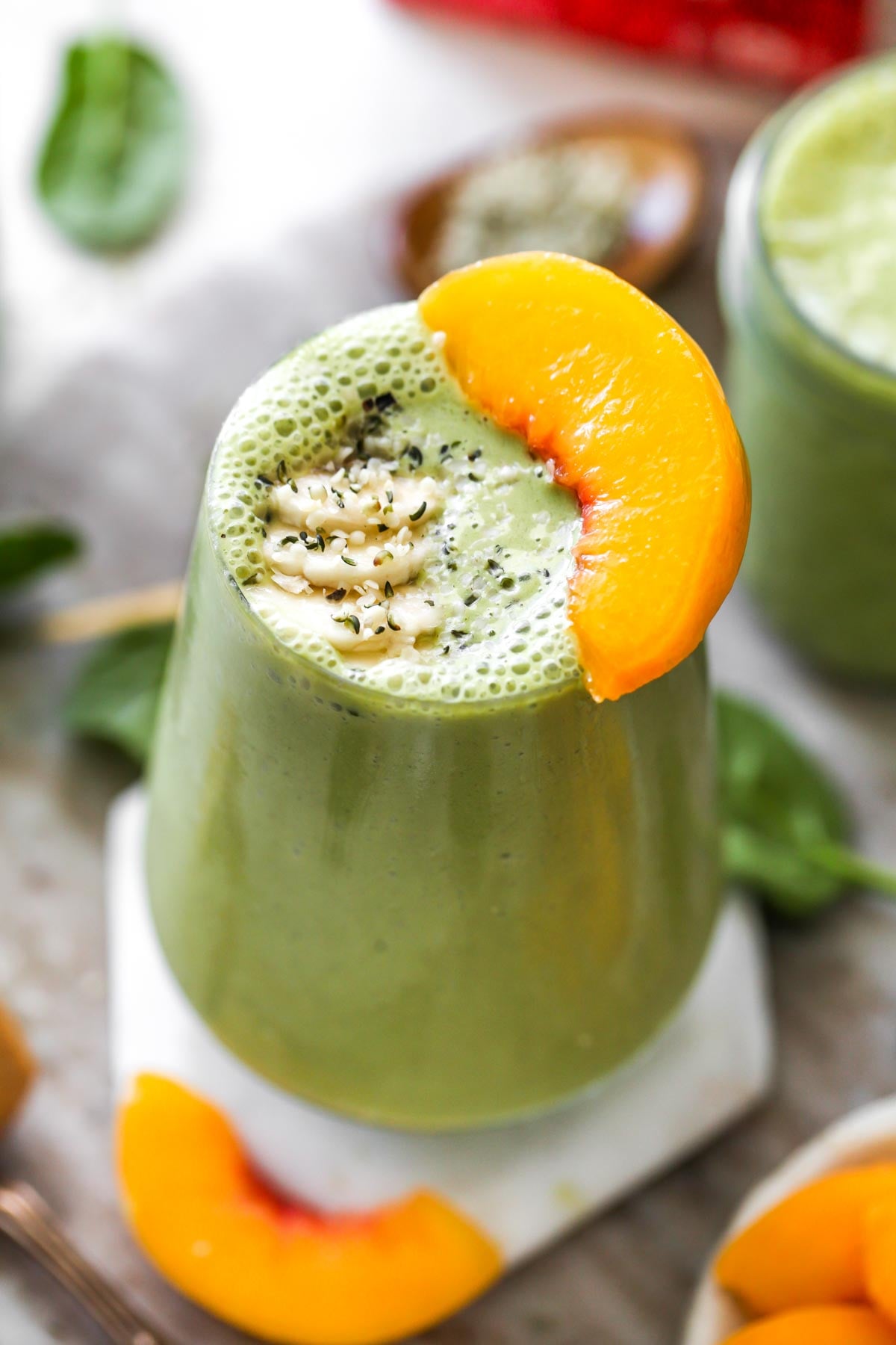 Green smoothie topped with banana slices and hemp seeds