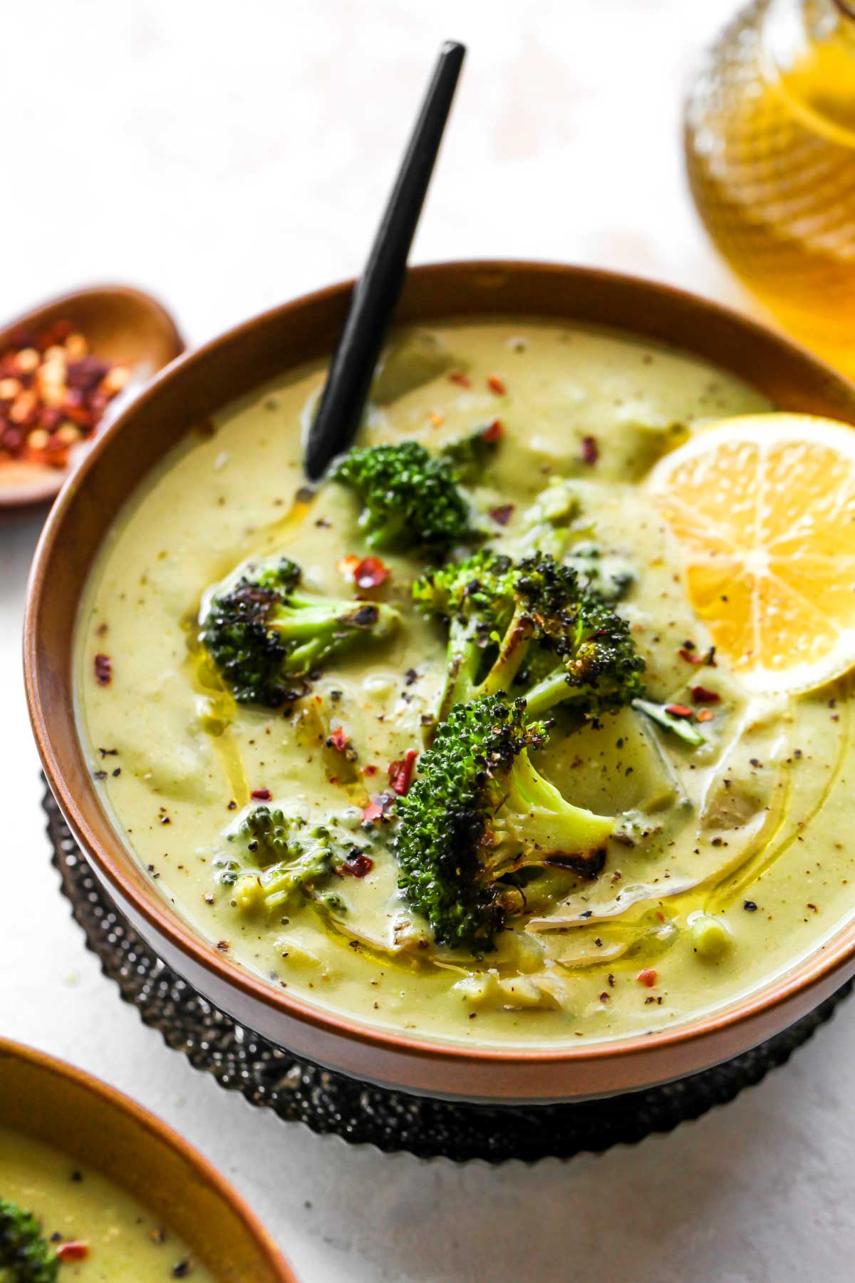 Spoon stirring a bowl of creamy broccoli soup