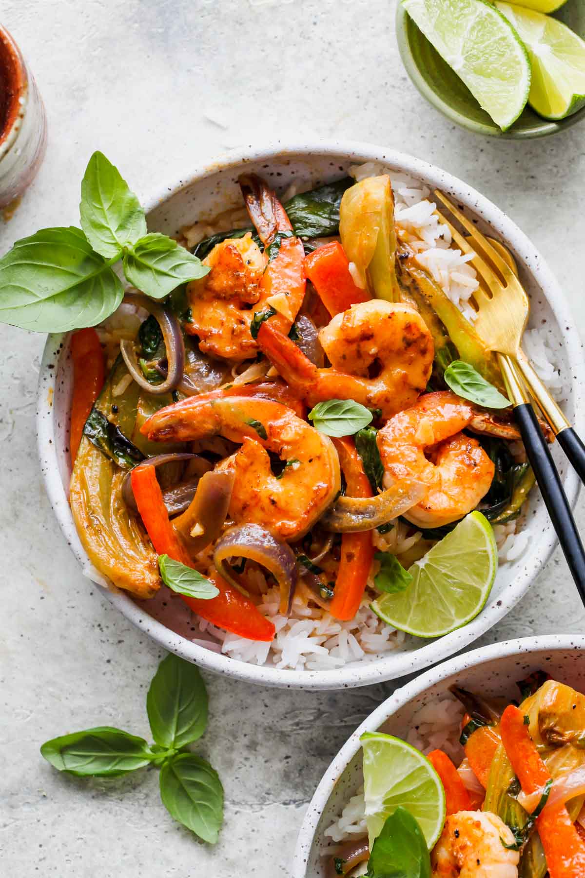 Shrimp, vegetables, and red curry served over rice in a bowl