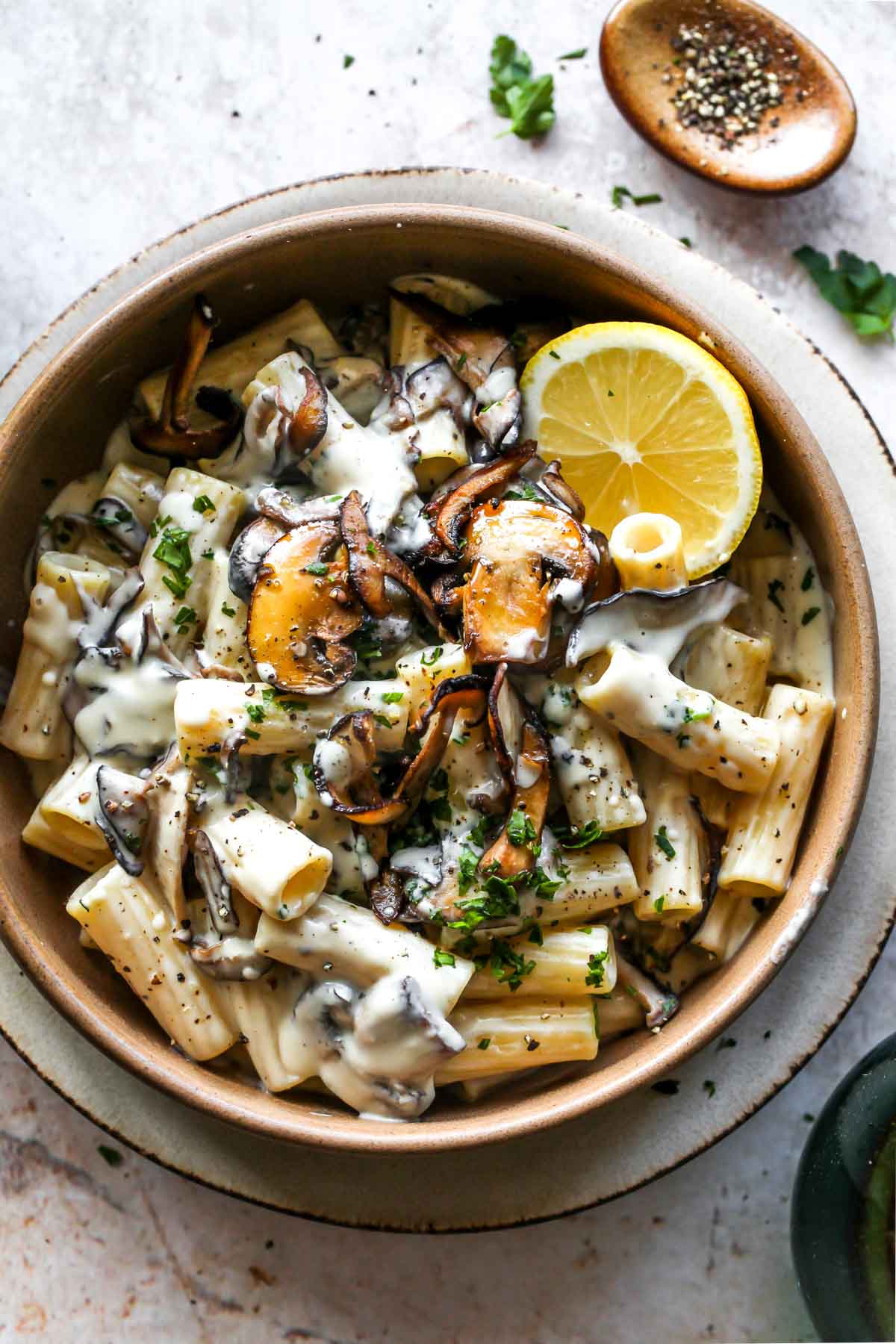 Mushroom pasta in a gold bowl with creamy vegan sauce