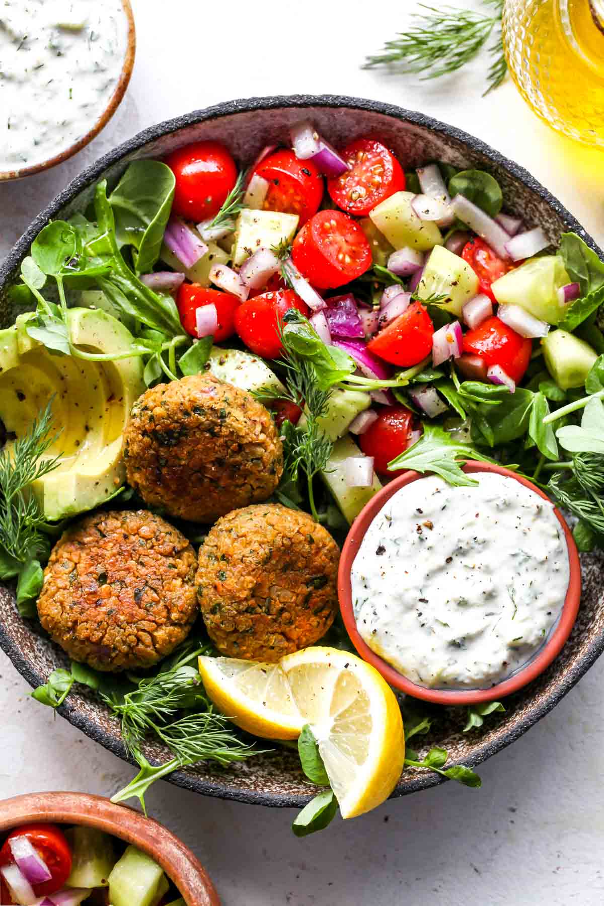 Falafel and vegan tzatziki served in a bowl with tomato salad