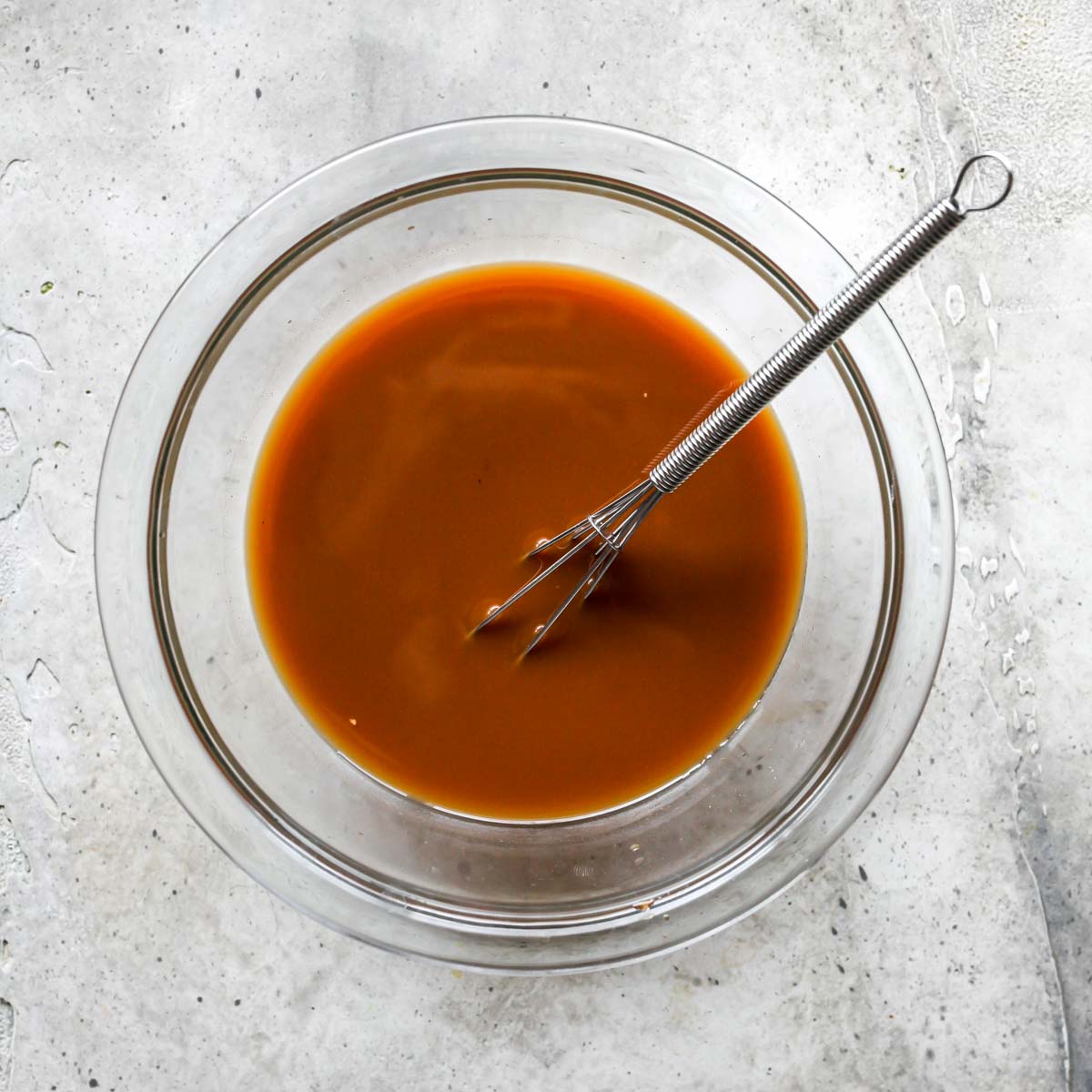 General Tso's sauce being whisked in a clear glass bowl
