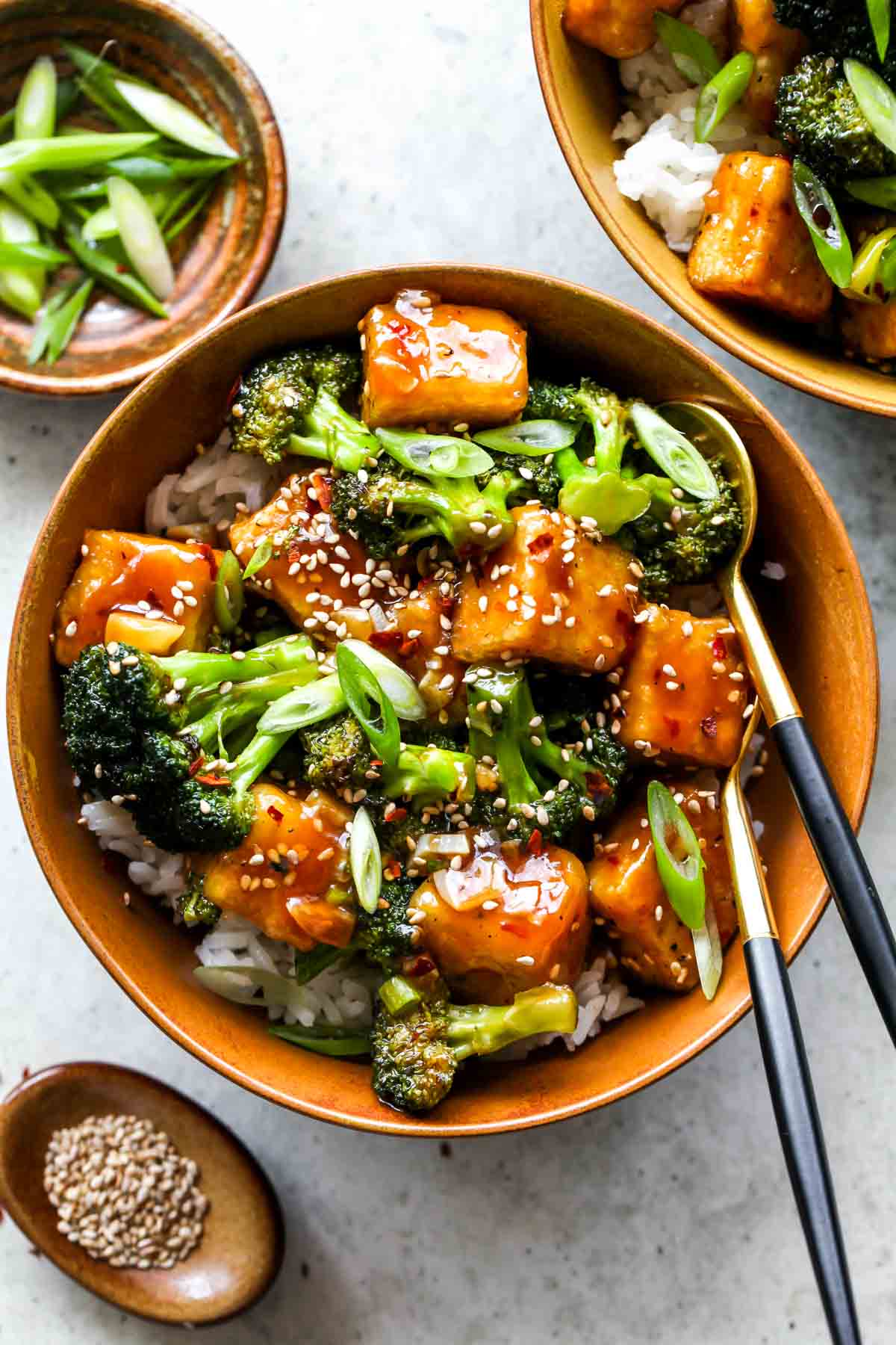 Cubes of tofu tossed in General Tso's sauce over rice with broccoli