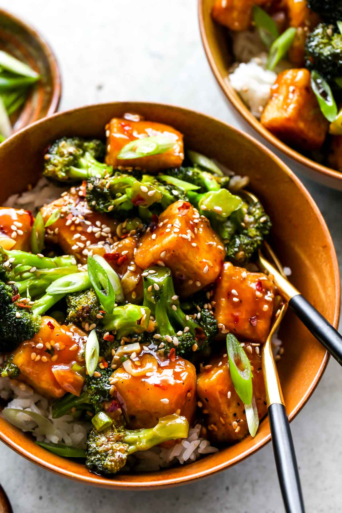 General Tso's Tofu and Broccoli served over rice in a gold bowl