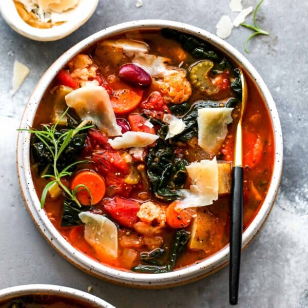 Bowl of vegetable soup with Parmesan and herb garnish