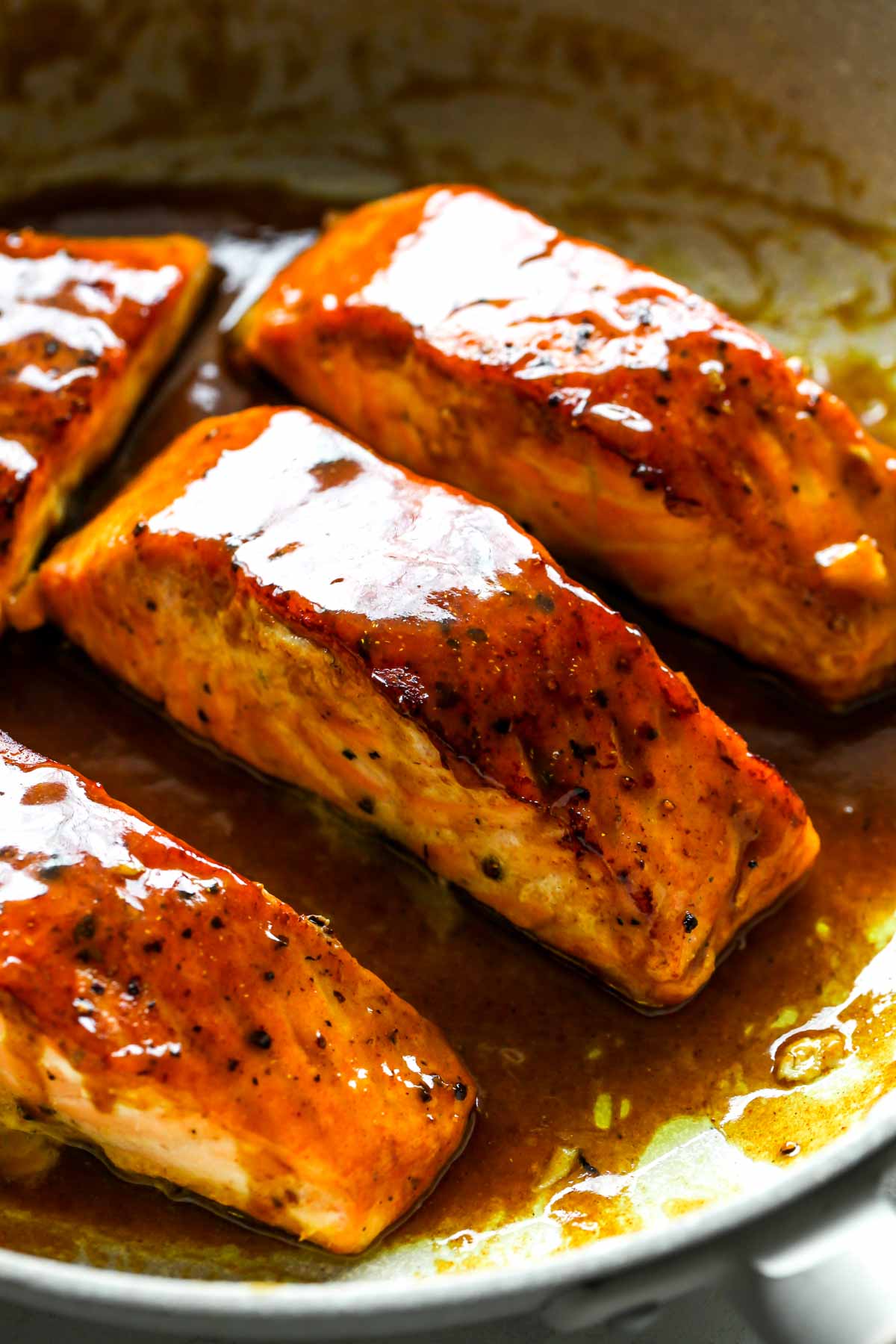 Close-up of glaze coating fish in a skillet