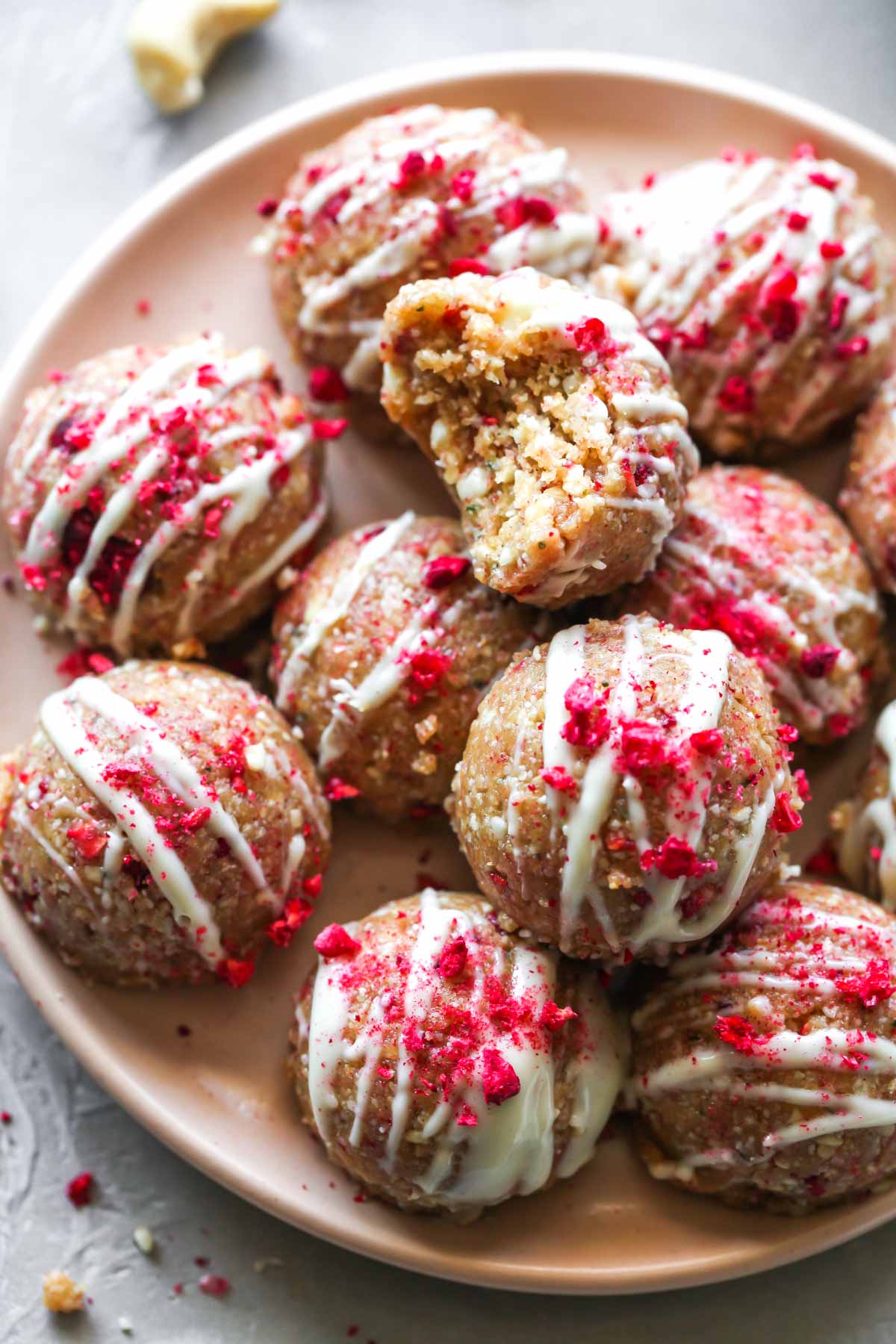 Raspberry White Chocolate Energy Balls with a bite taken out to show inside