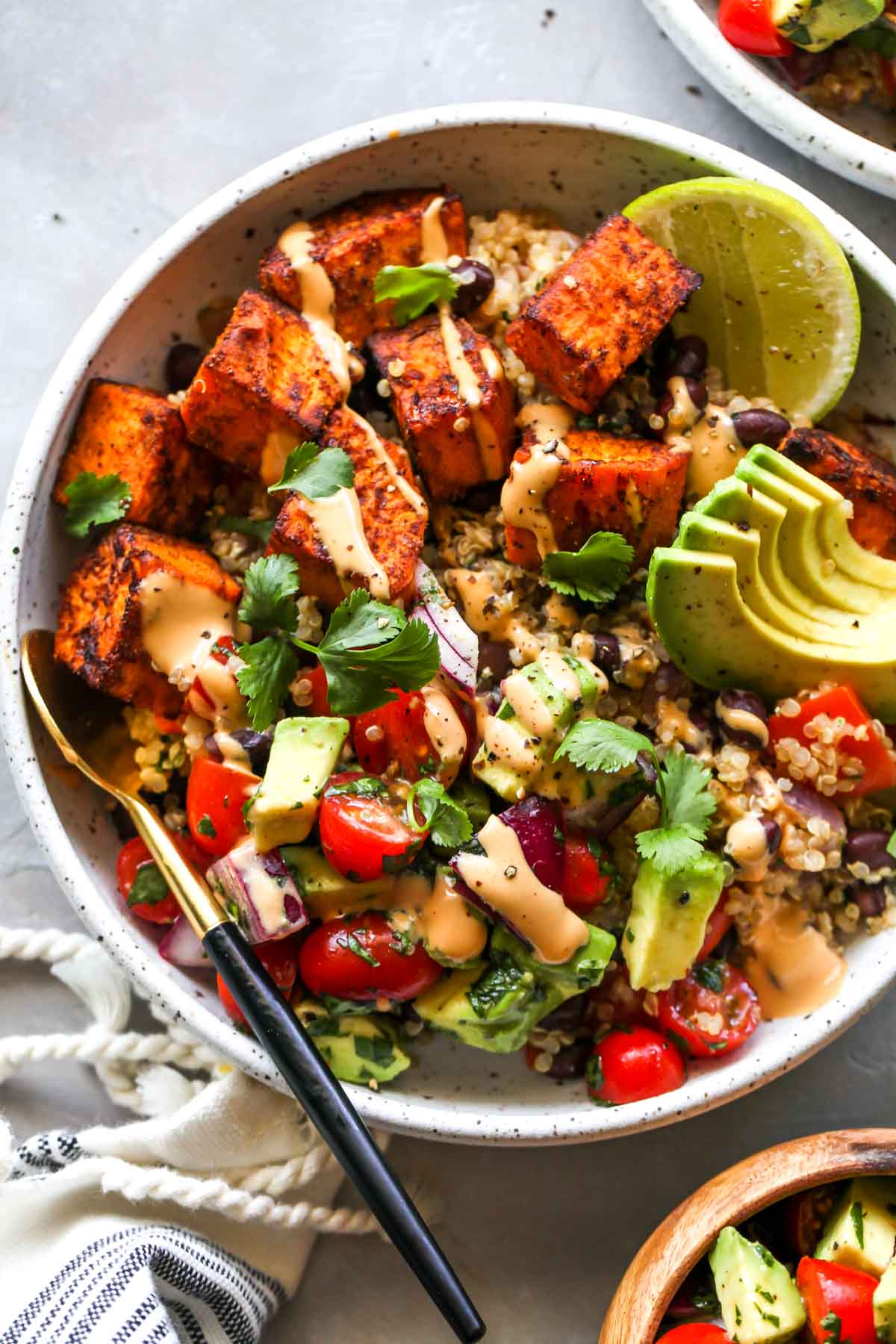 Sweet potatoes, quinoa, black beans, and pico de gallo in a white bowl
