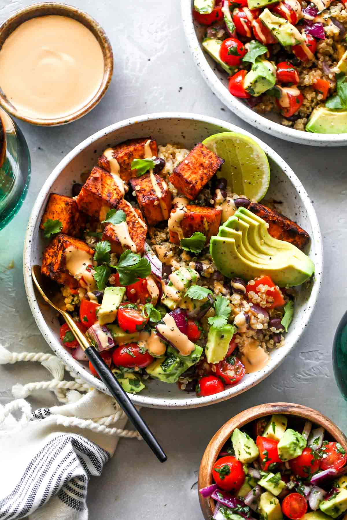 Assembled vegetarian burrito bowls with chipotle tahini sauce on the side