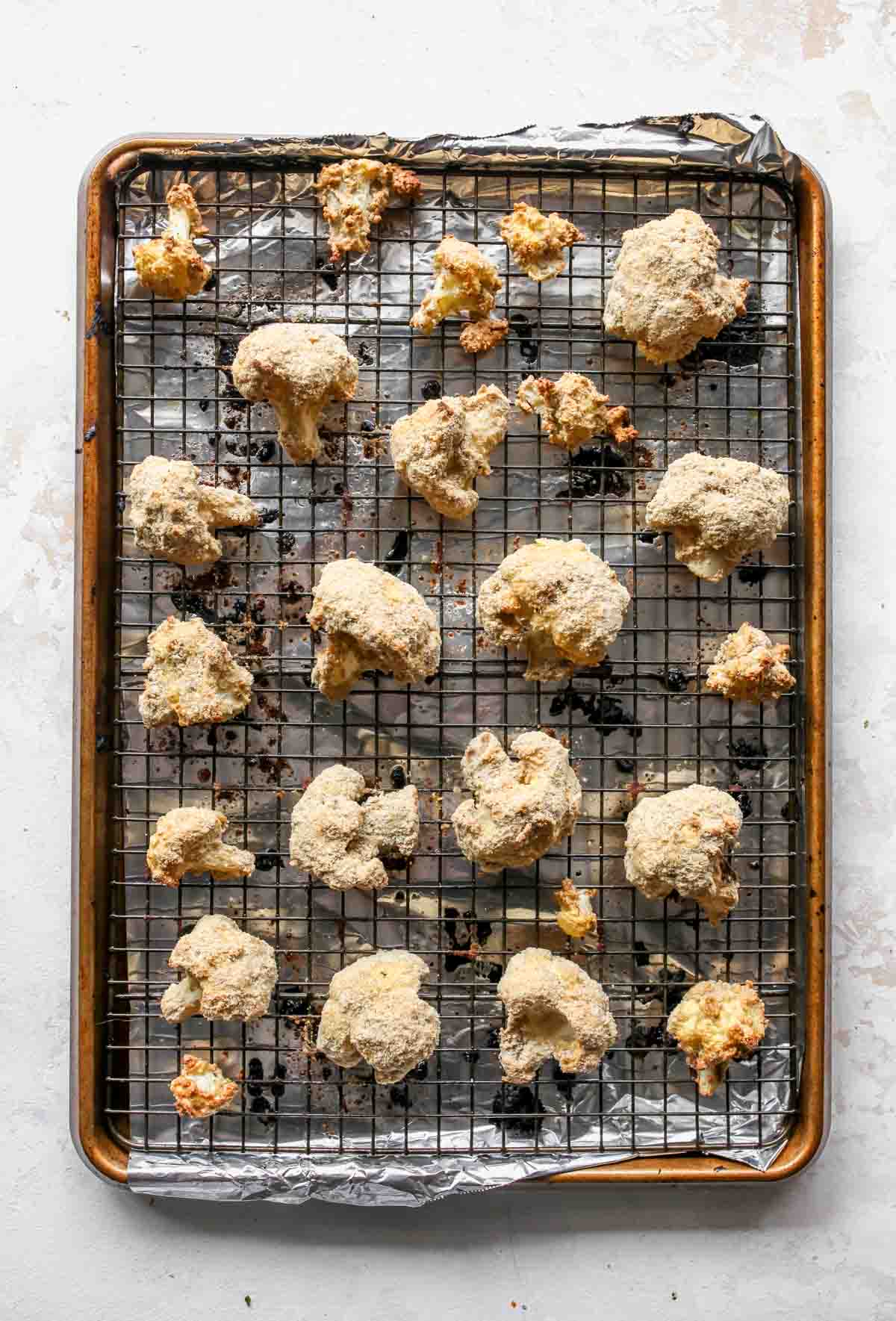 Breaded cauliflower florets on a prepared baking sheet