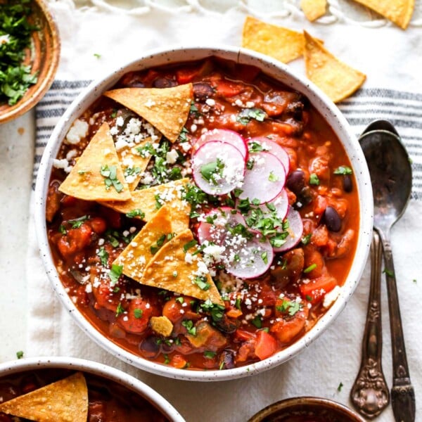 Mole Poblano Chili topped with radish, cilantro, and tortilla chips