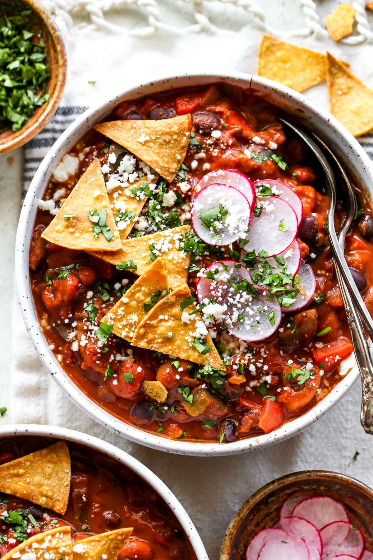 Serving of mole chili in a white bowl with a spoon resting on the side