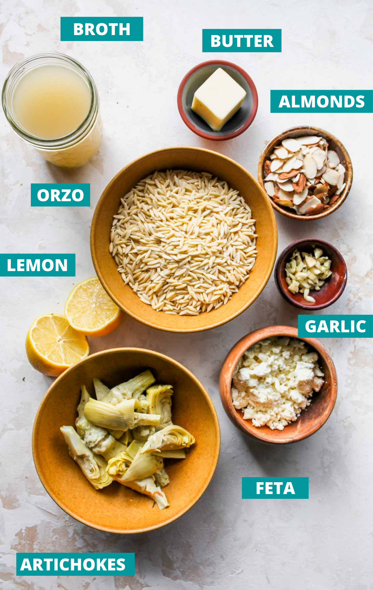 Orzo salad ingredients in separate bowls with blue labels