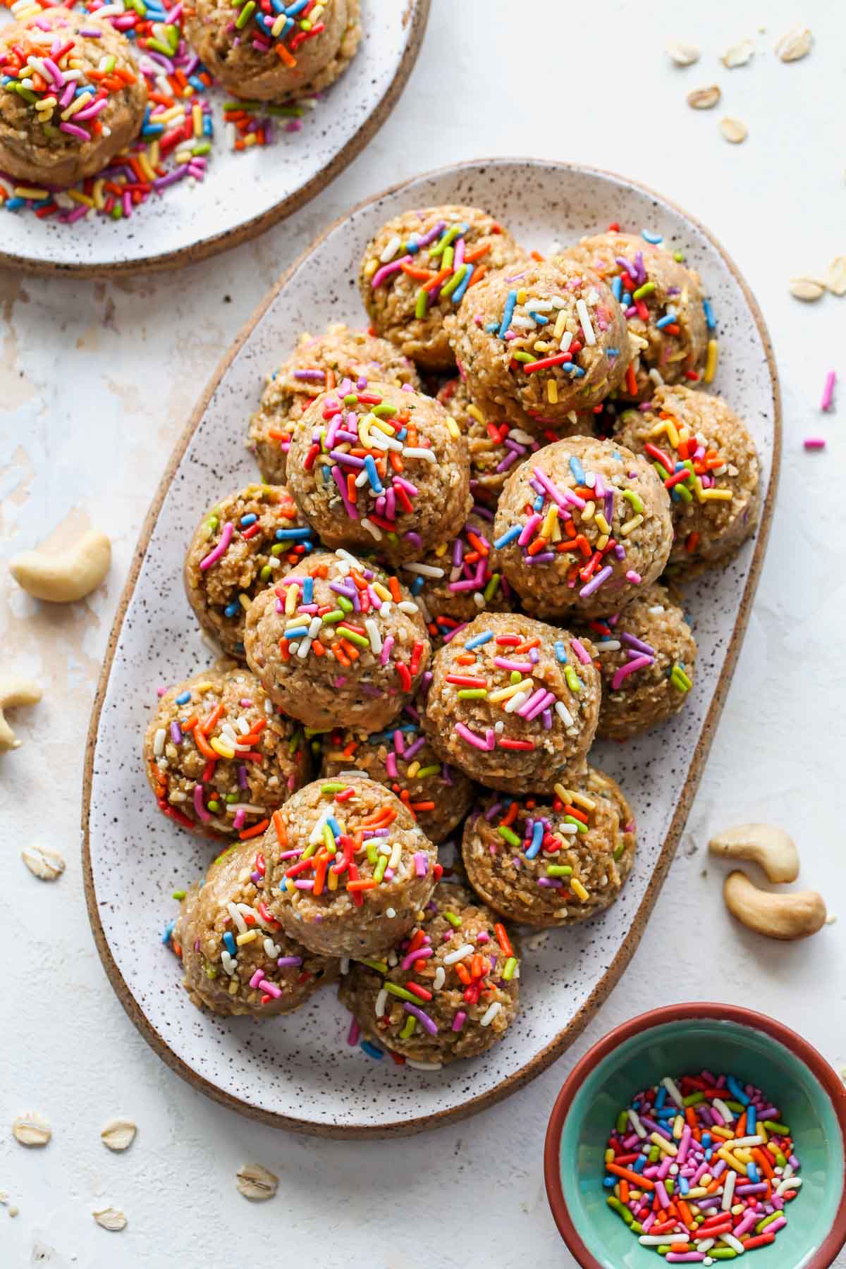 Cake Batter Energy Bites on a platter coated in sprinkles