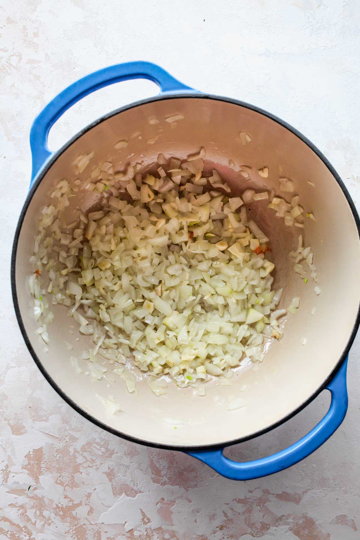Onion and garlic sauteing in a Dutch oven