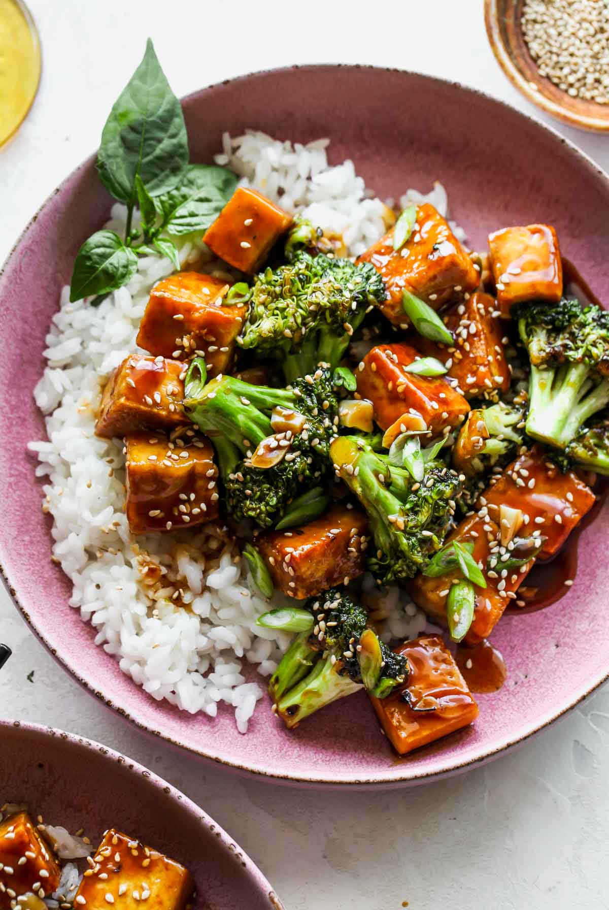 Finished recipe in a pink bowl topped with teriyaki sauce