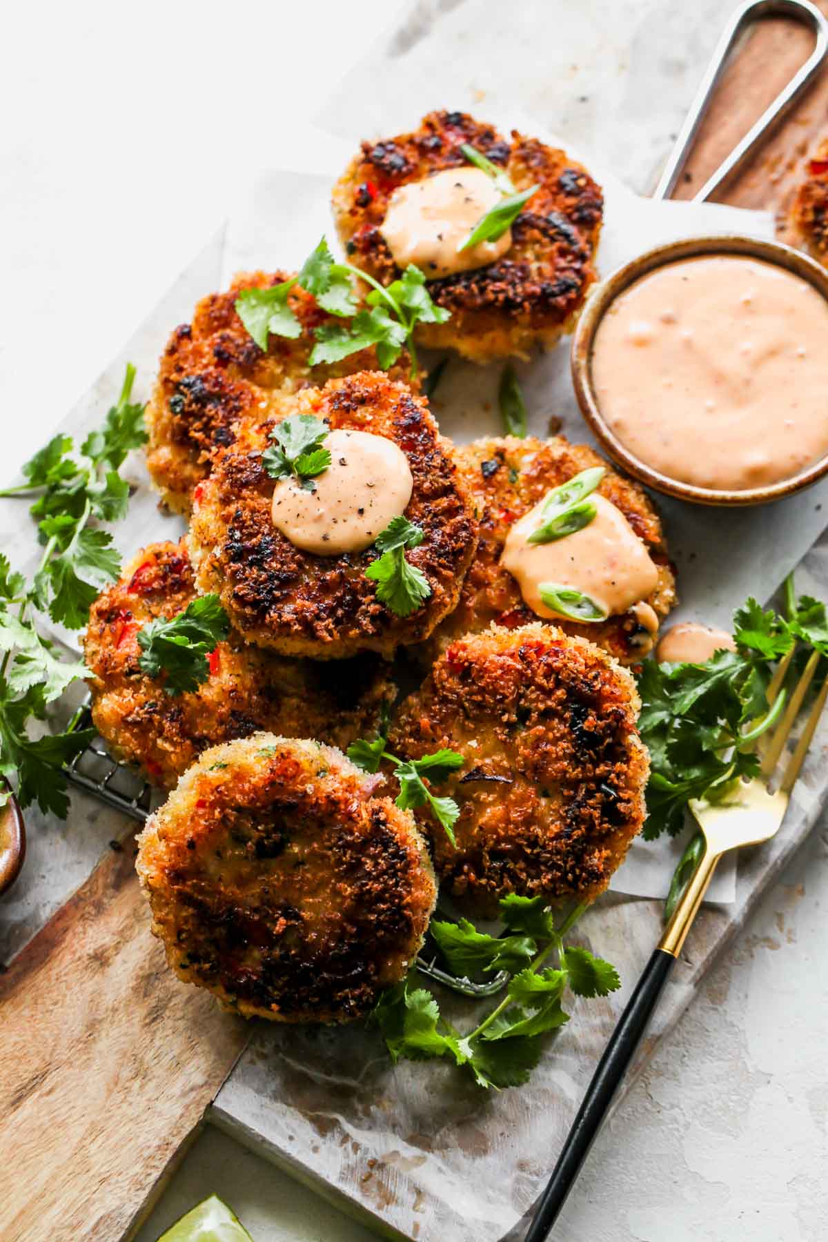 Shrimp cakes on a platter with a bowl of chili aioli