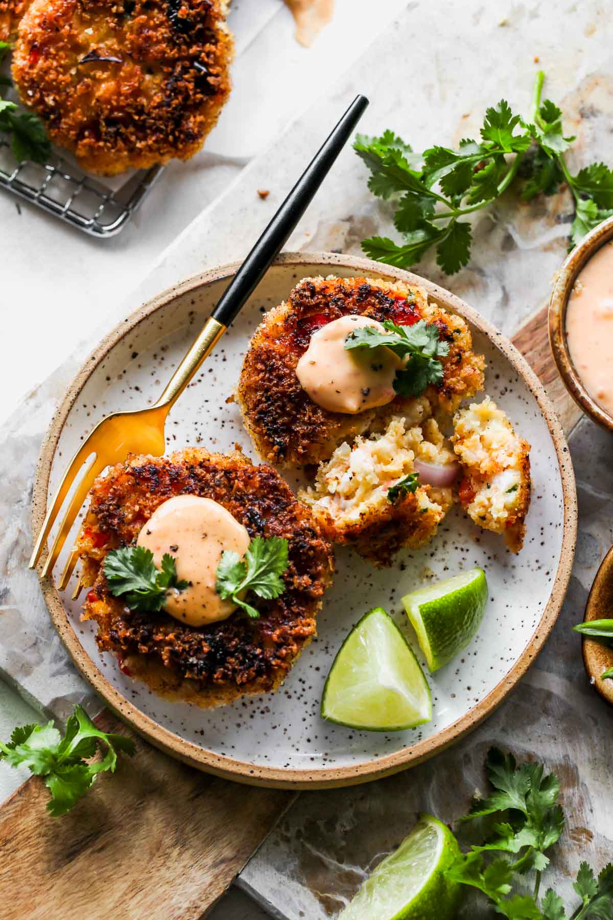 Shrimp cakes styled on a plate with cilantro and aioli for dipping
