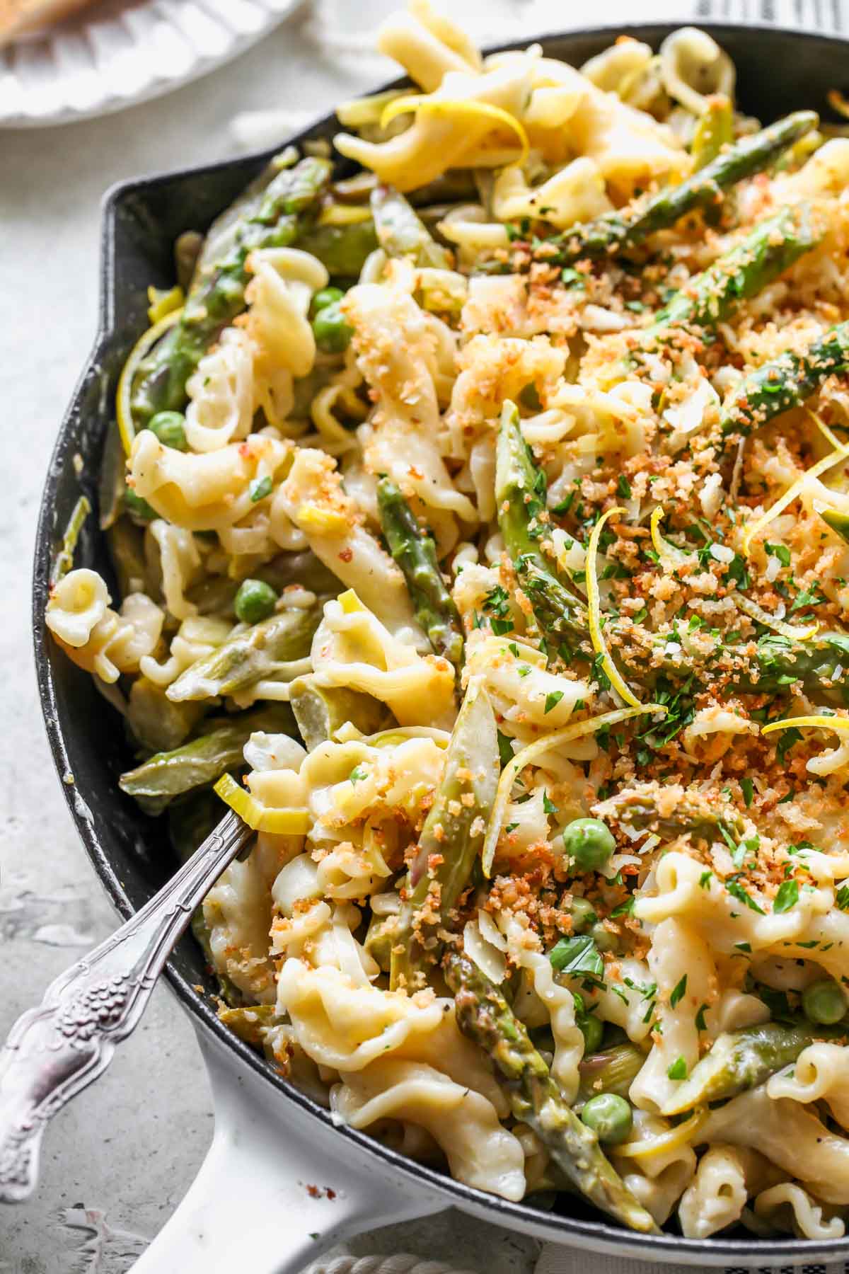 Serving spoon pulling pasta out of a skillet