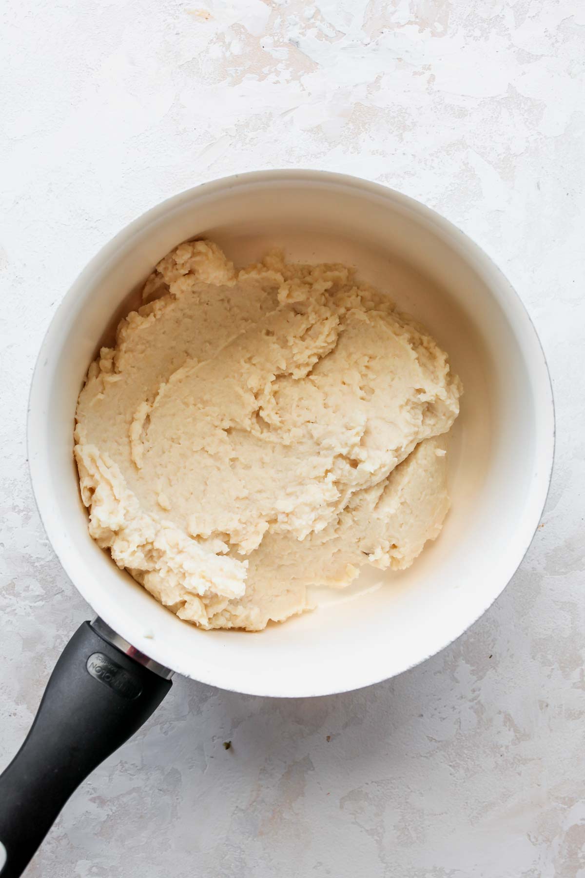 Butter bean mash being warmed in a small saucepan