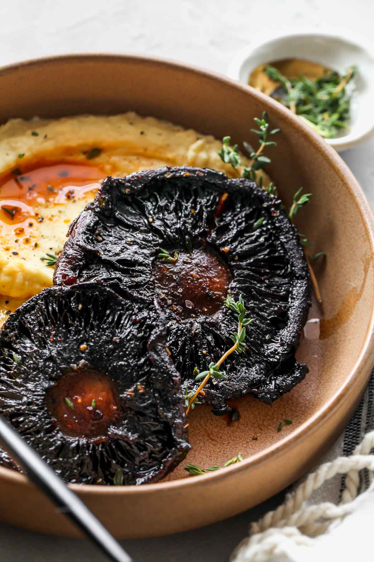 Roasted portobello mushrooms on a plate garnished with fresh tyme