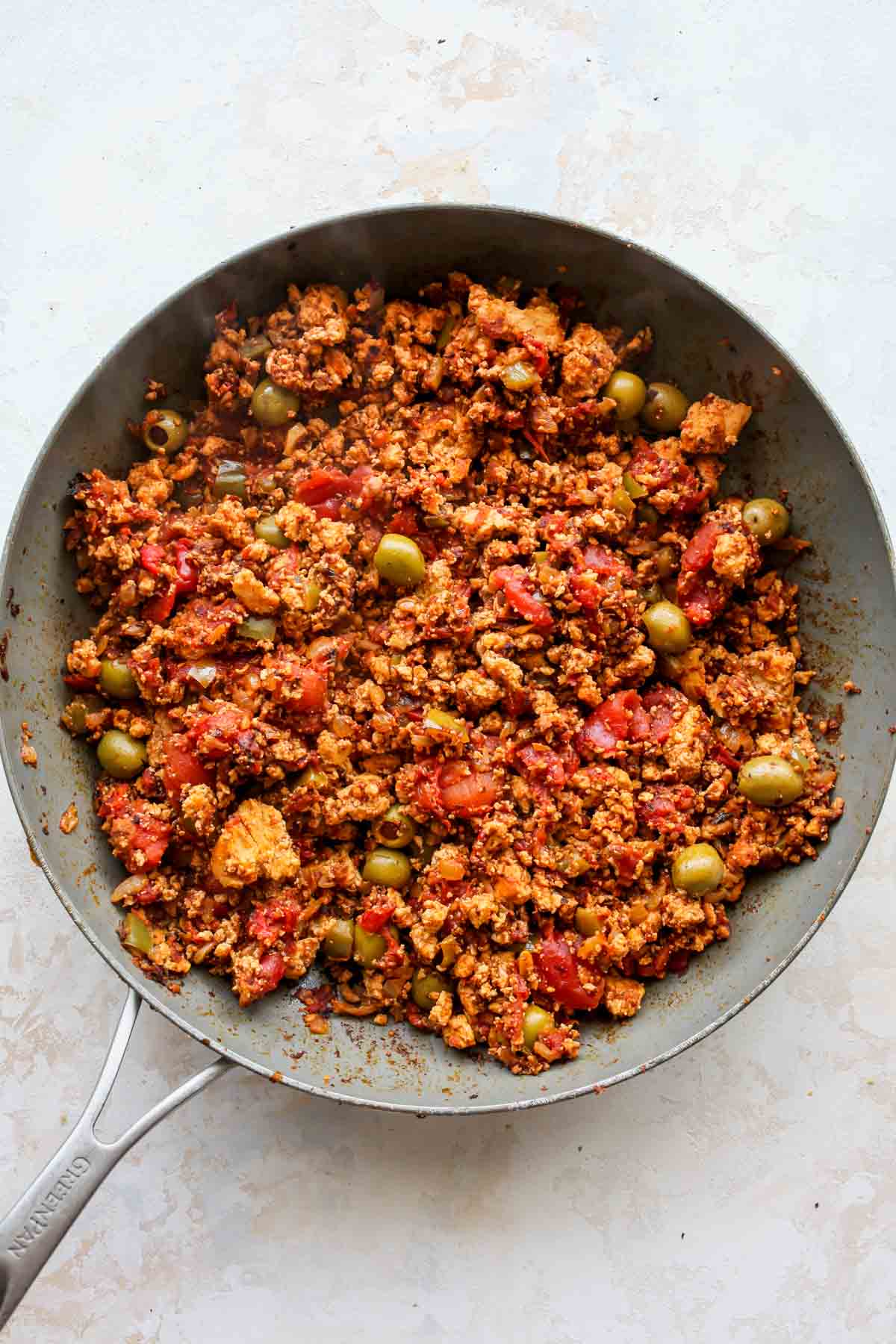 Tofu and tomato mixture being simmered in a large skillet