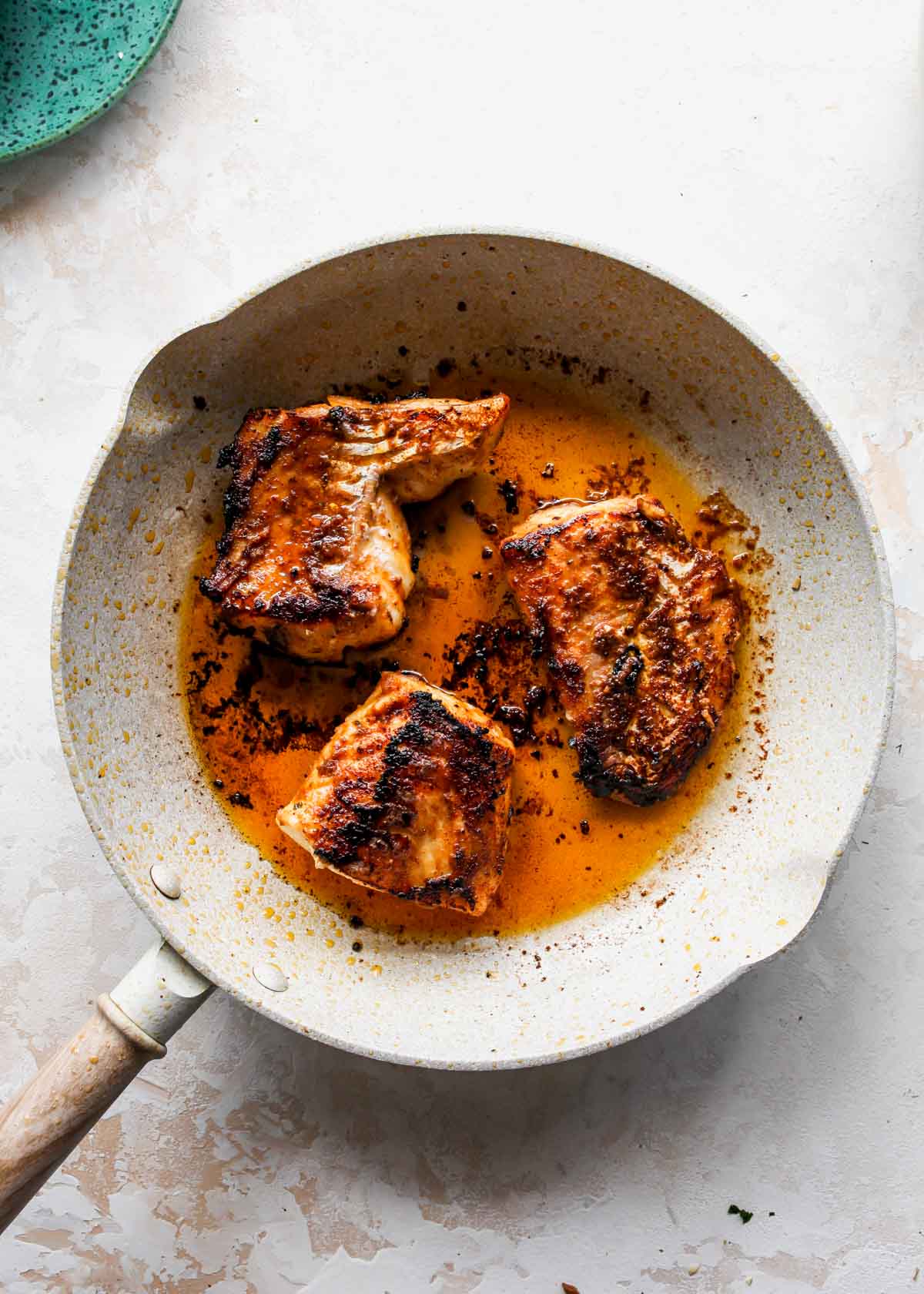 Seasoned cod being pan-seared in a skillet