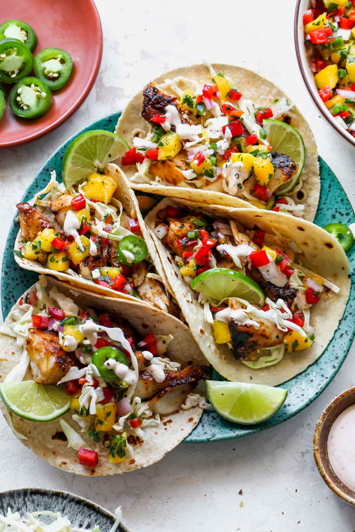 Platter of fish tacos topped with slaw and mango salsa