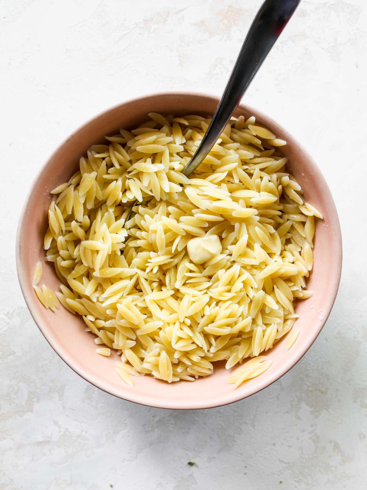 Orzo pasta in a pink bowl