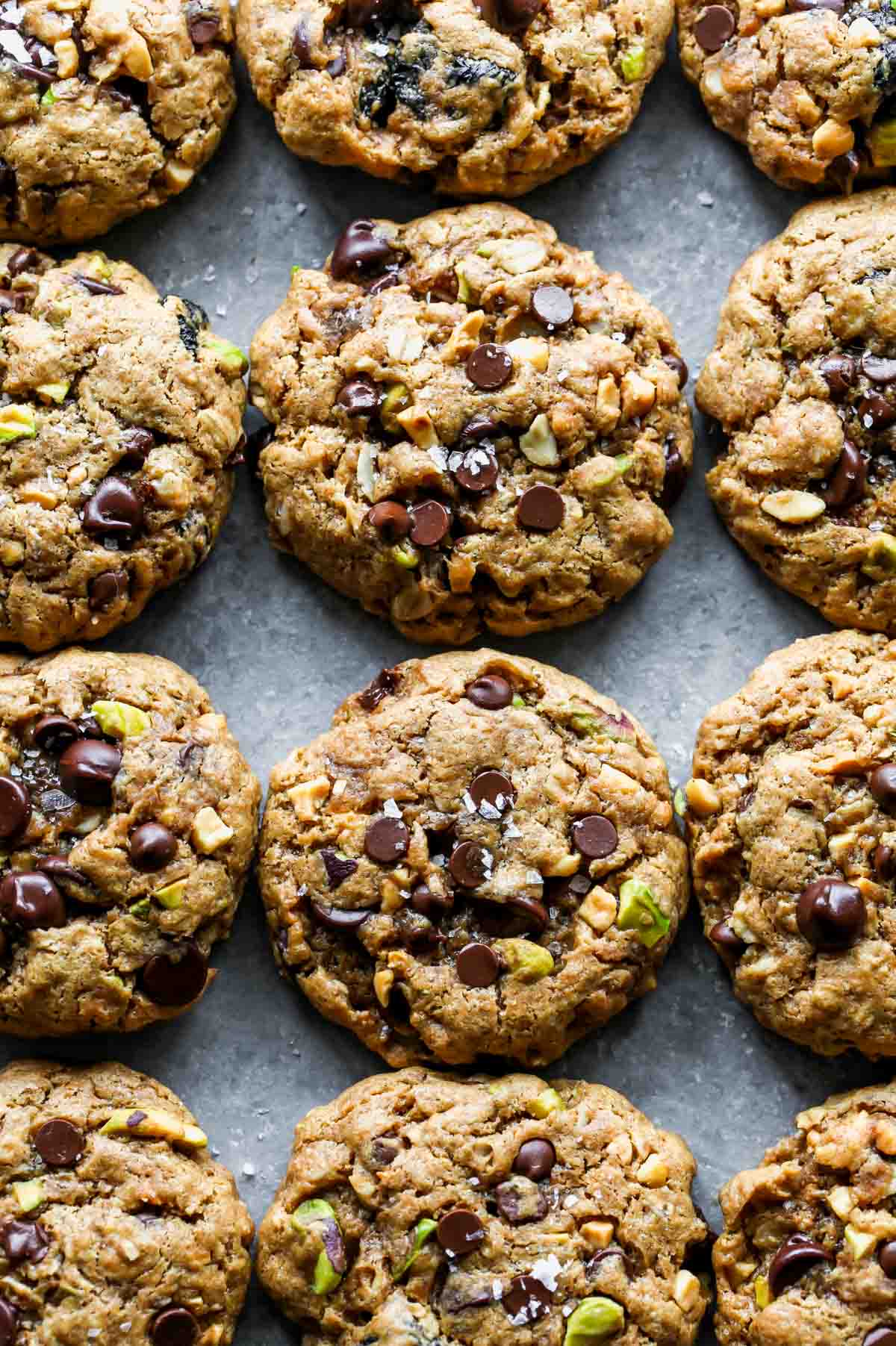 Baked cookies stacked next to each other on a grey surface