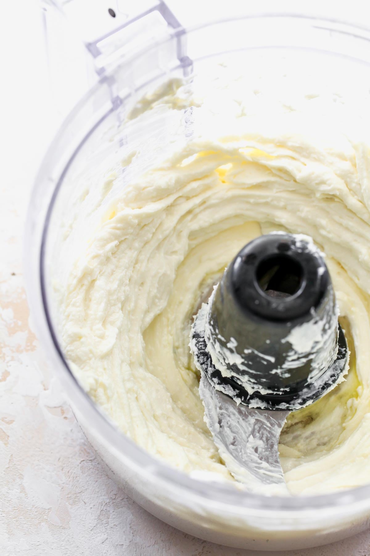 Feta being whipped in a food processor until smooth