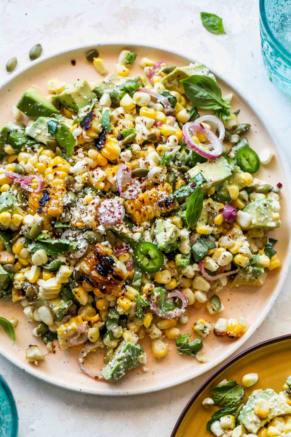 Corn salad with avocado, herbs, and shallot dressing on a plate