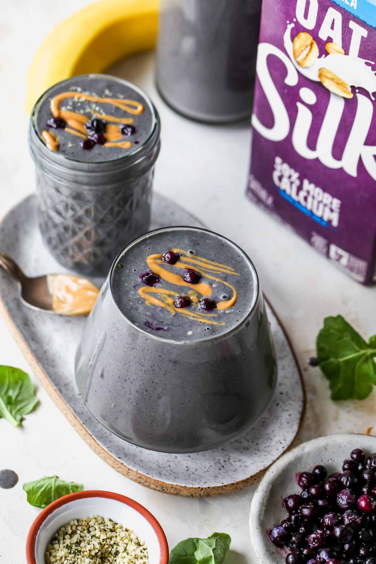 Silk Oatmilk carton next to a berry smoothie