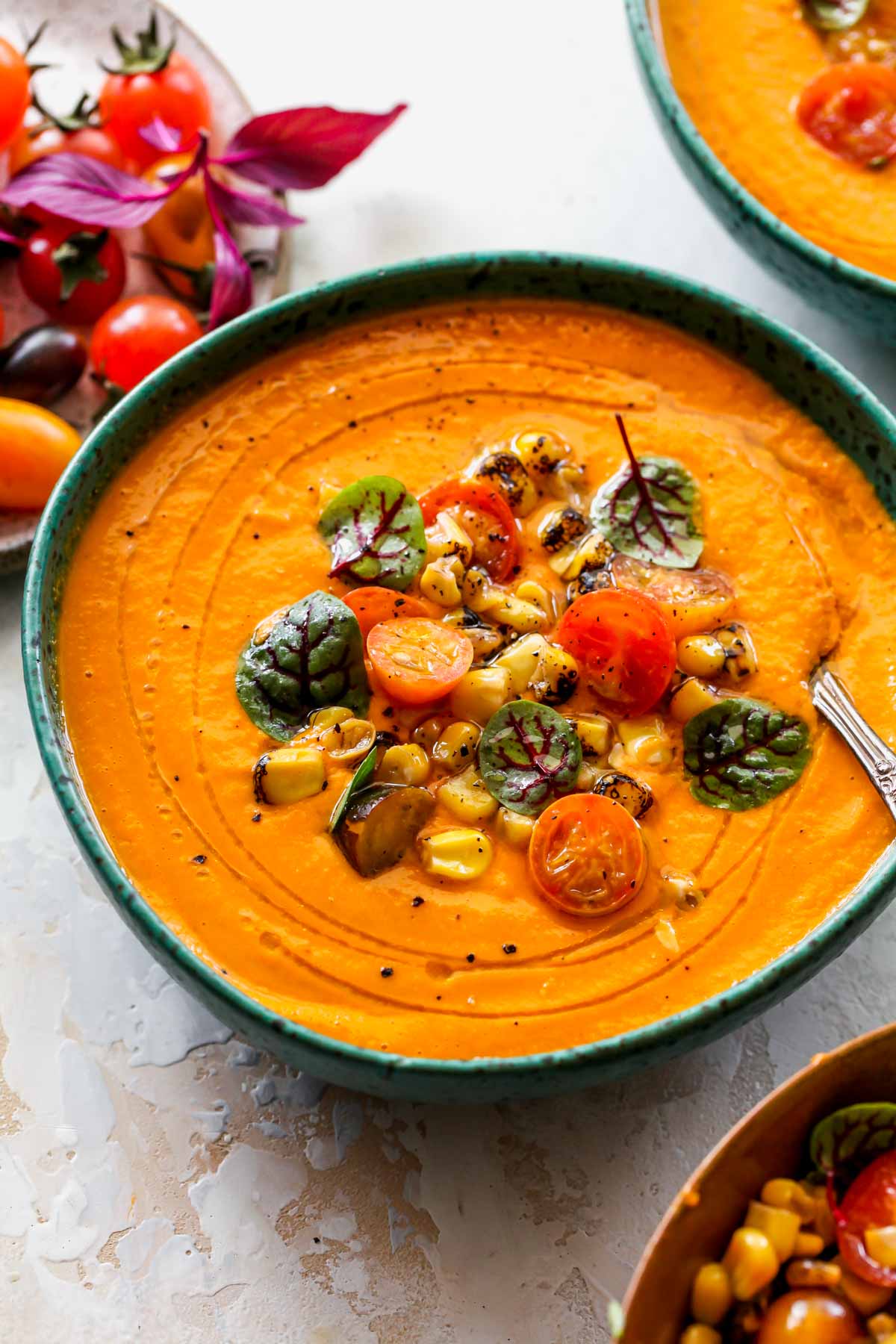 A spoon taking a bite out of tomato soup