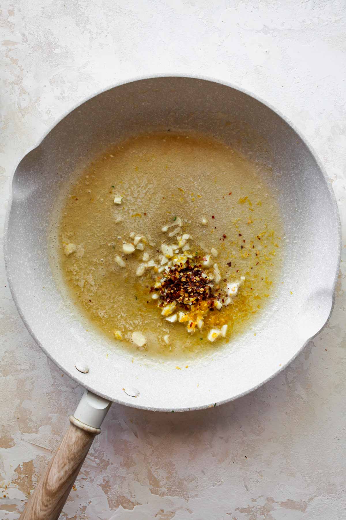 Lemon butter, chili flakes, and garlic sauteing in a skillet
