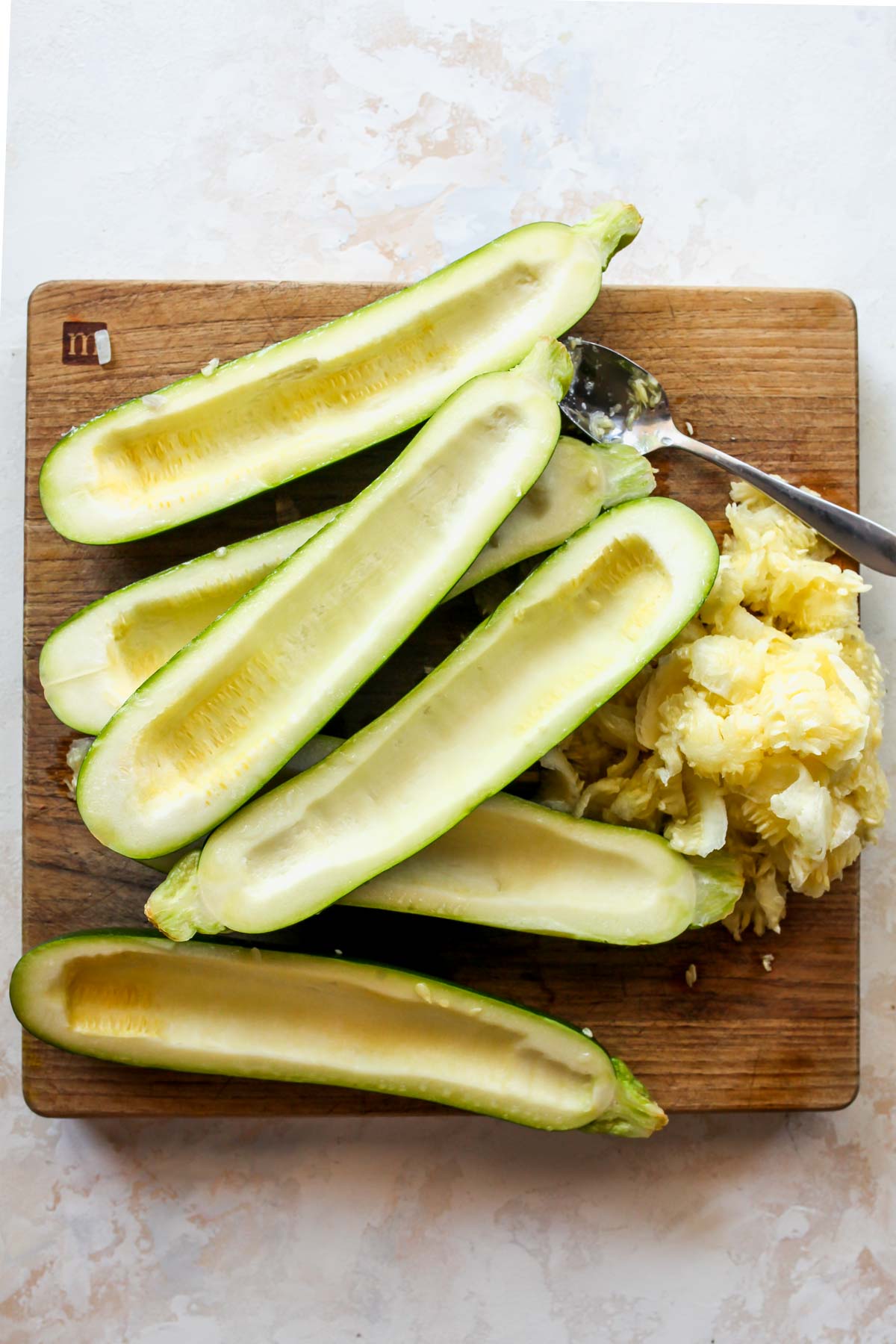 Zucchini flesh being scooped out with a spoon