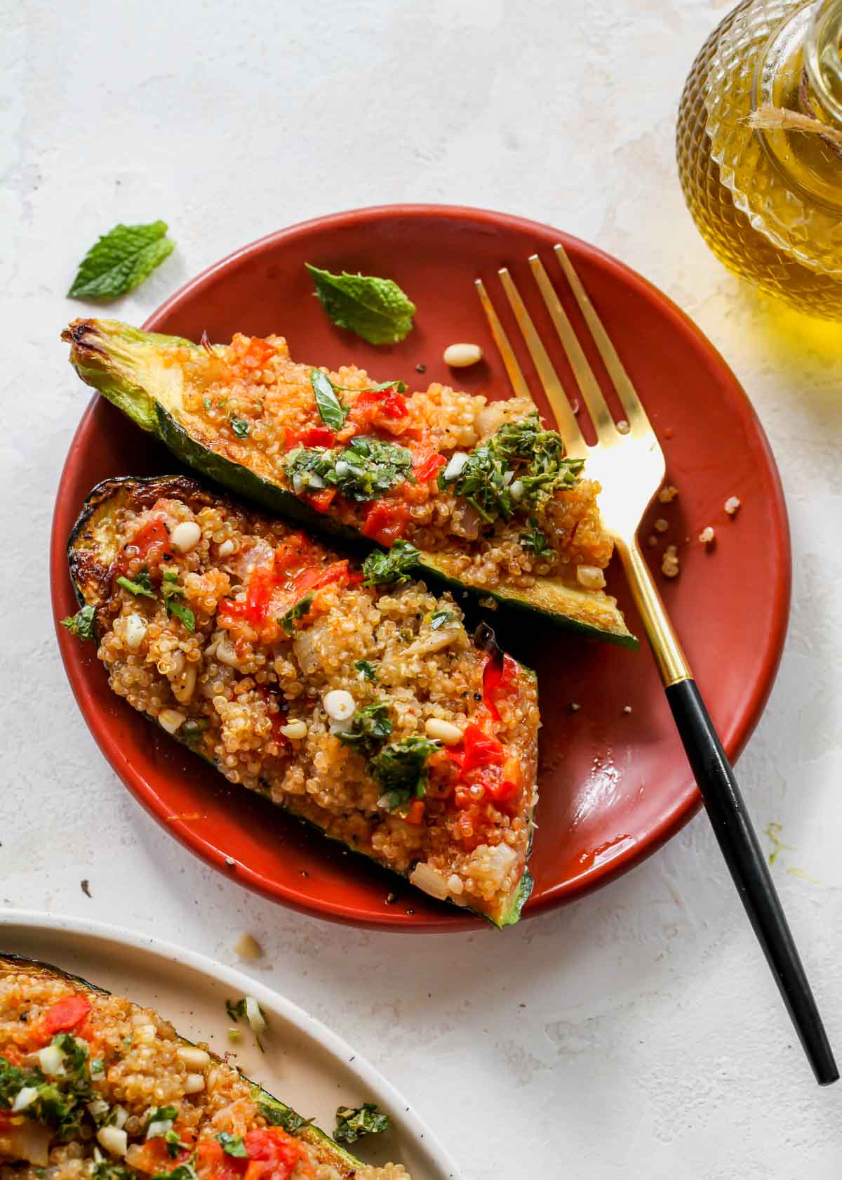 A stuffed zucchini being sliced in half on a plate