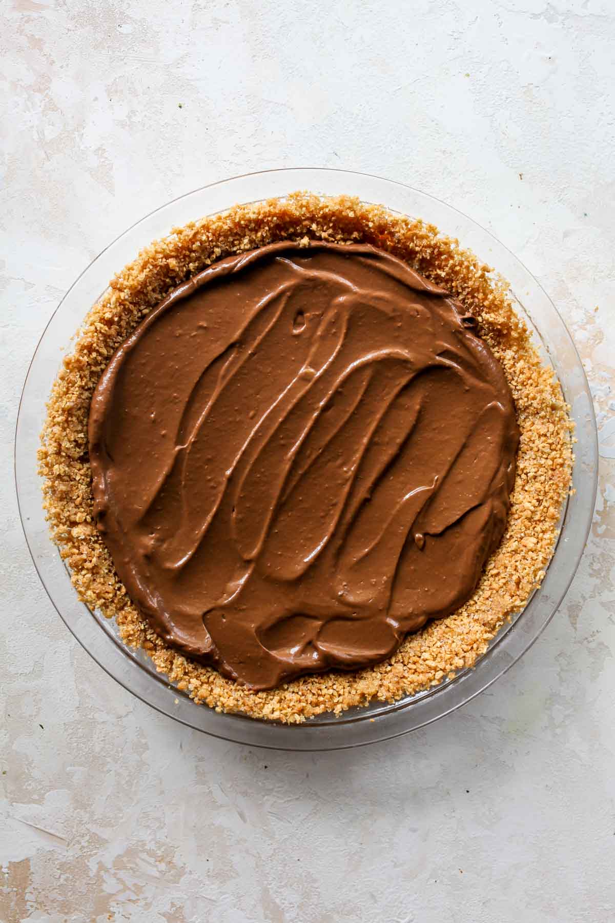 Chocolate pudding being spread in a pie crust