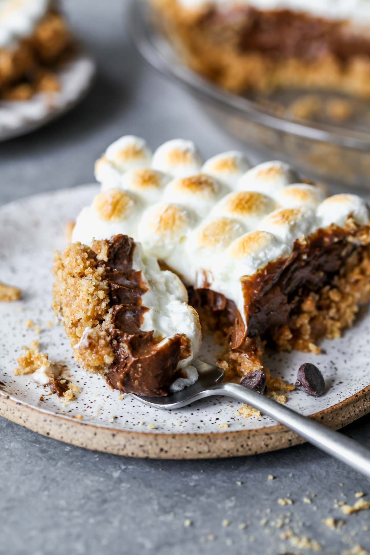 S'mores pie on a plate with a fork taking a bite out