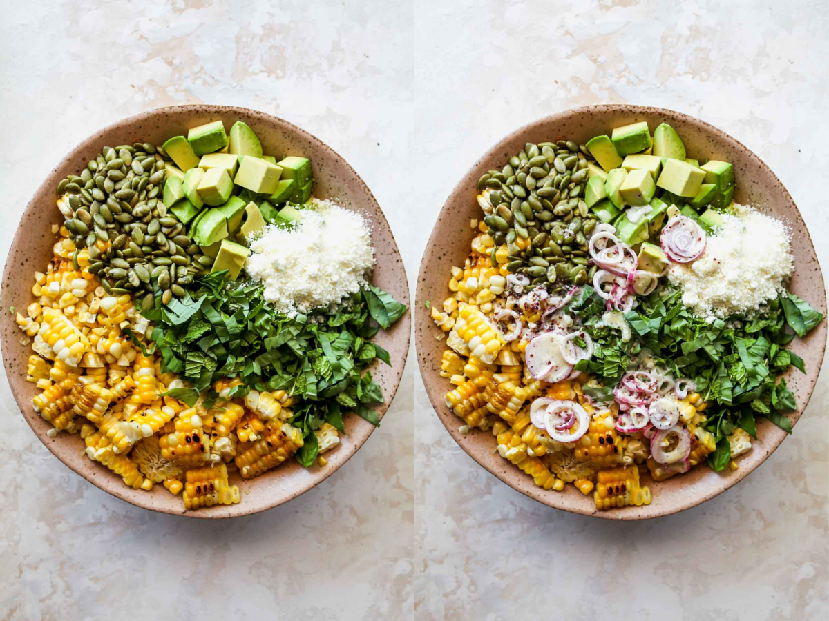 Corn, herbs, avocado, and seeds being tossed with dressing in a pink bowl