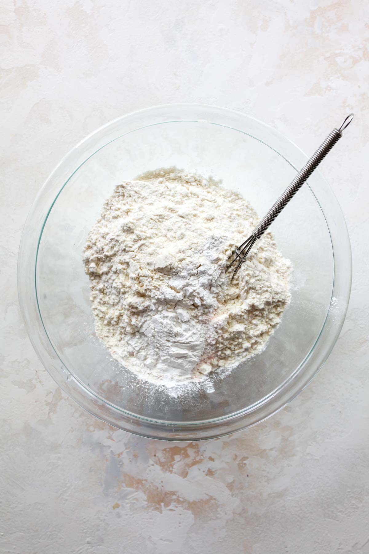 Flour, baking soda, and salt being mixed in a bowl